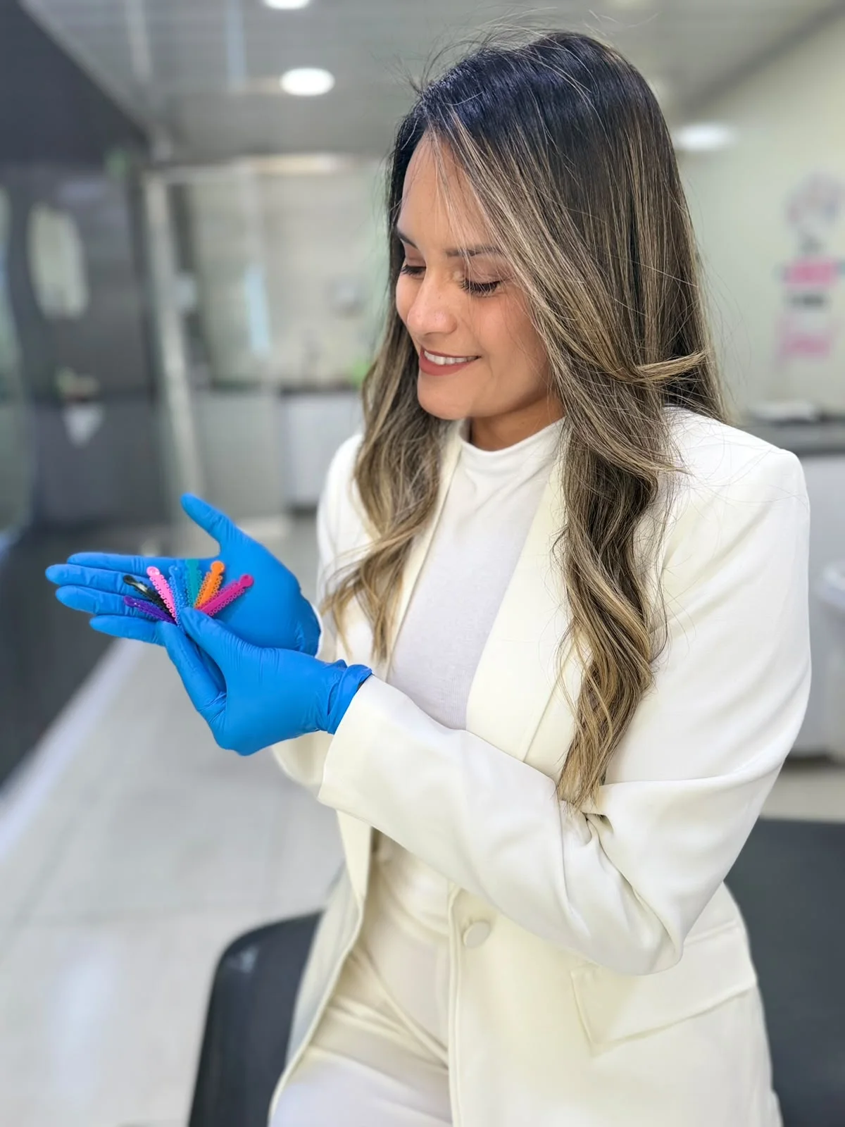 Dra. Laura Durán colocándose guantes para preparar una consulta